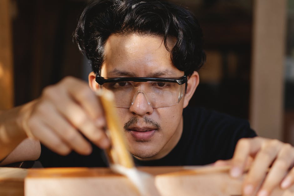 A close-up image of a brush applying restoration materials to a damaged painting.