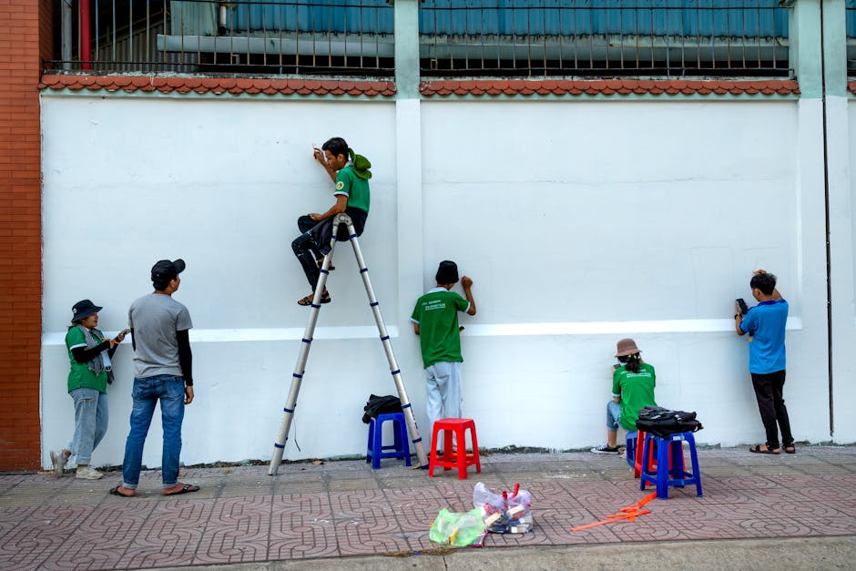 A diverse group of people working together on a large community mural