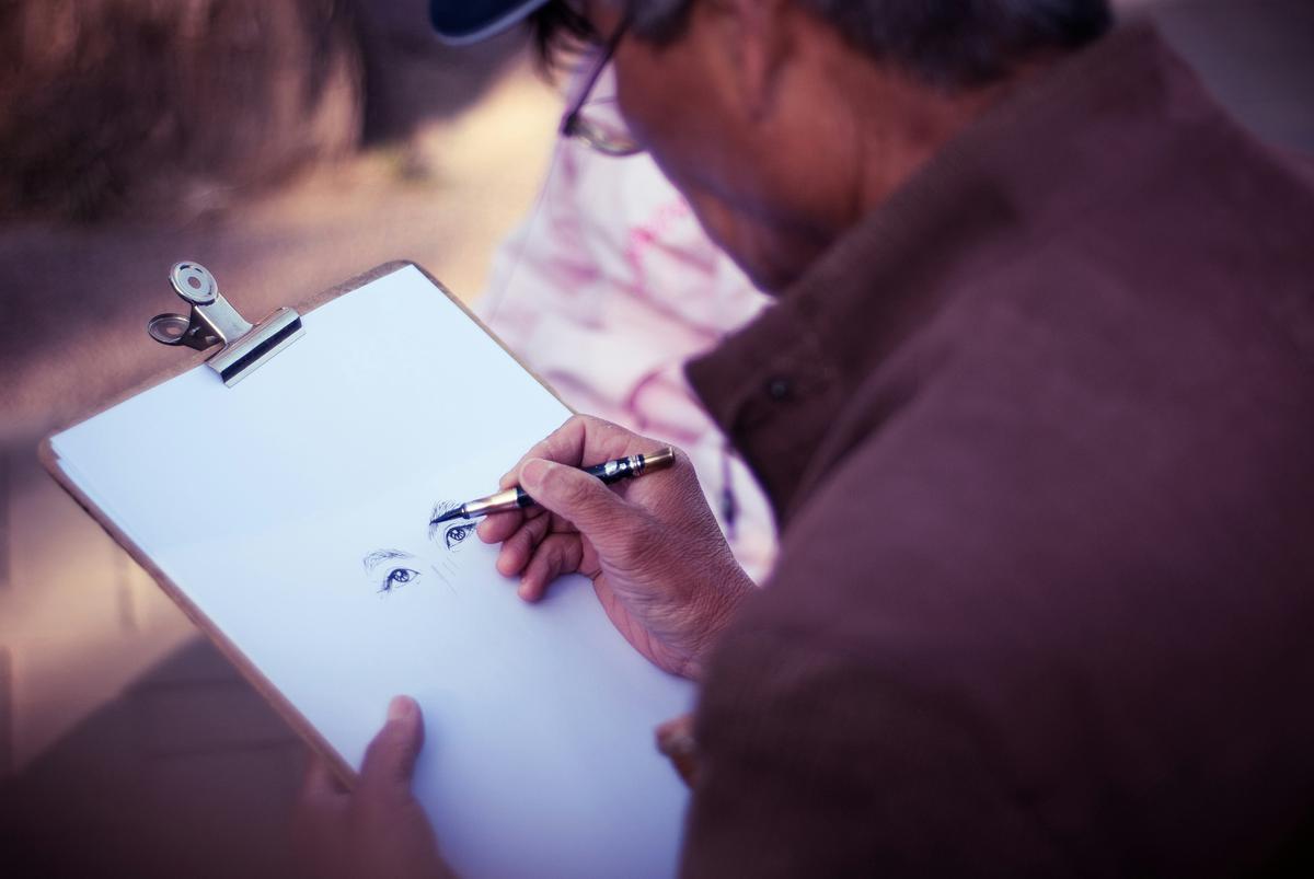 An image representing the concept of a creative block, showing a person with a paintbrush staring at a blank canvas