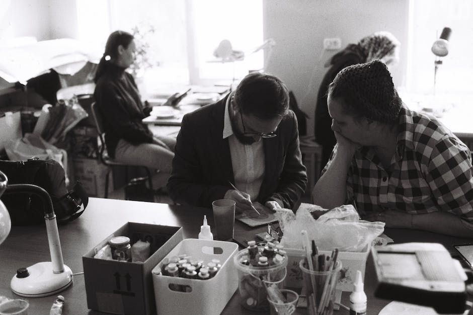 A group of artists working on their paintings in a studio setting