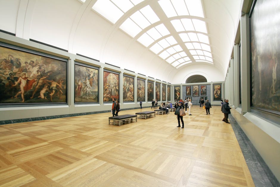 Image of a painting exhibition with people viewing artworks