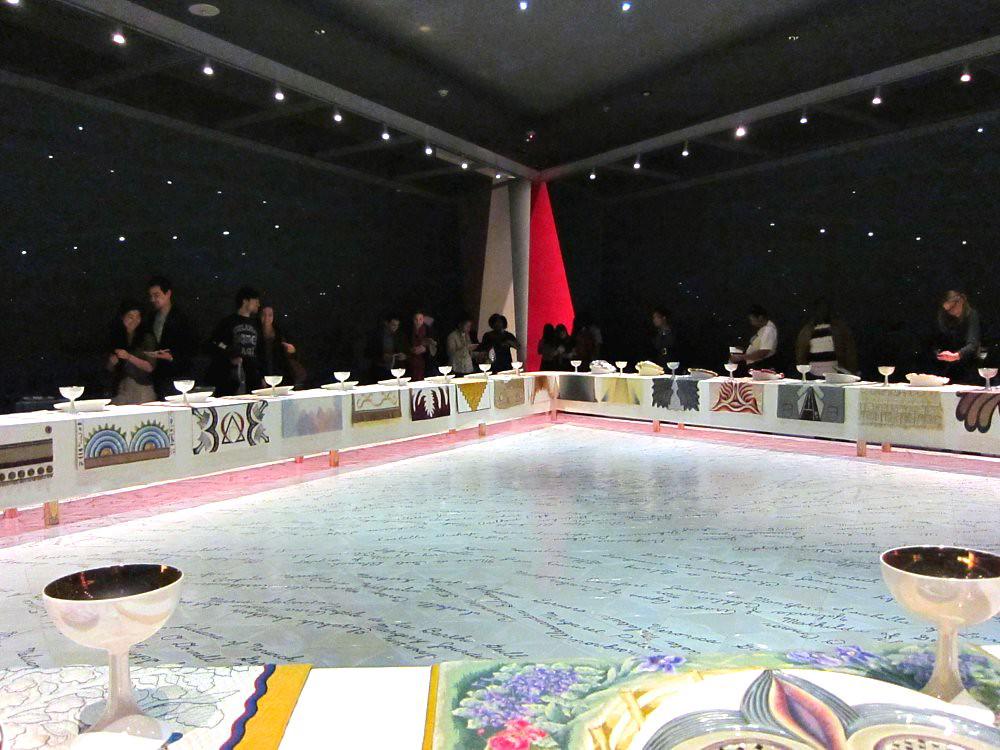 A detailed view of Judy Chicago's The Dinner Party installation, showcasing the intricate place settings and symbolic imagery