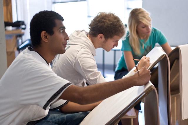 Artists sketching a model during a life drawing session