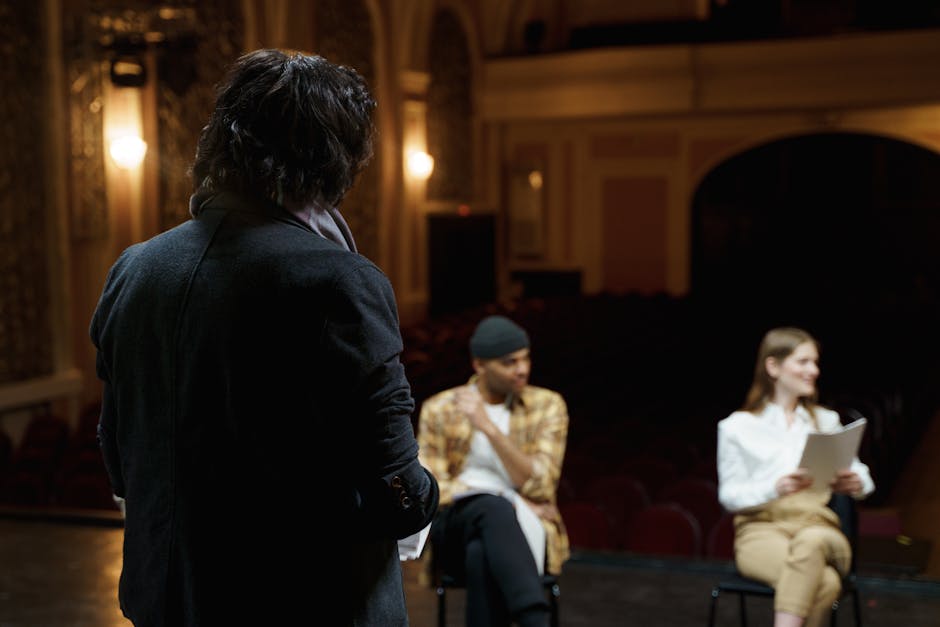 A theater director and actors in intense discussion during rehearsal