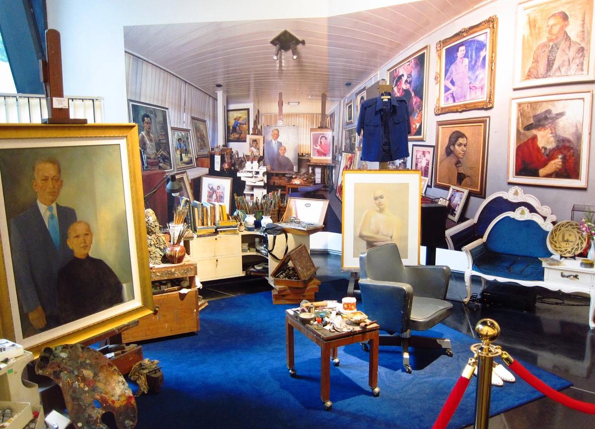 A Renaissance artist's studio with various portrait paintings