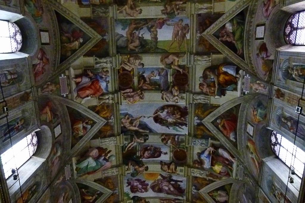 A detailed close-up of the Sistine Chapel ceiling, showcasing Michelangelo's vibrant use of color in the Creation of Adam scene