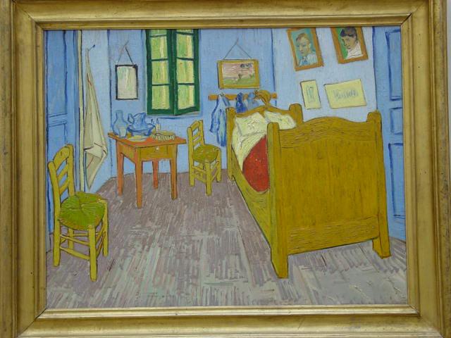 A recreation of Vincent van Gogh's room at the Saint-Rémy-de-Provence asylum, with a small window offering a view of the night sky.