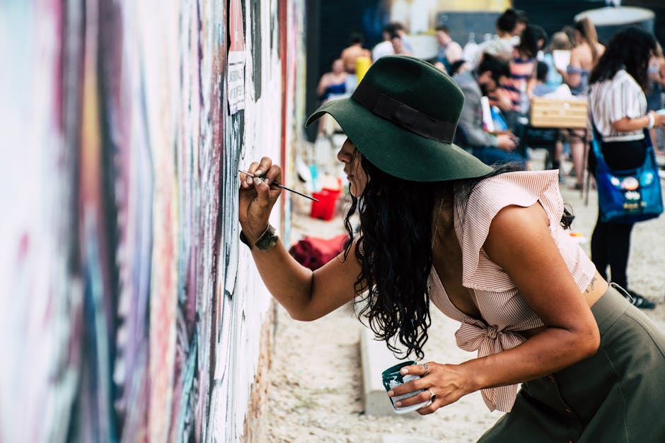 A group of women of color artists collaboratively working on a large-scale community mural